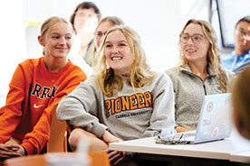 Students smiling in class. Link to Beneficiary Designations